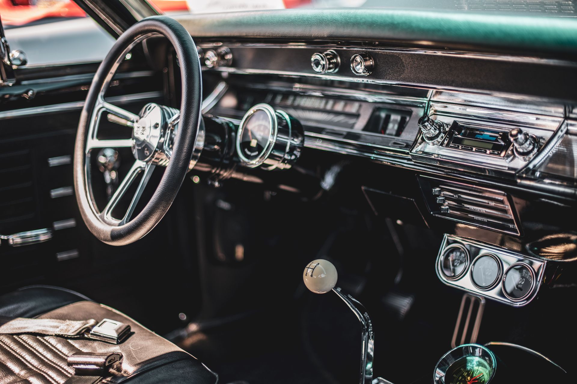 A detailed view of a classic car's interior featuring a vintage dashboard and steering wheel.